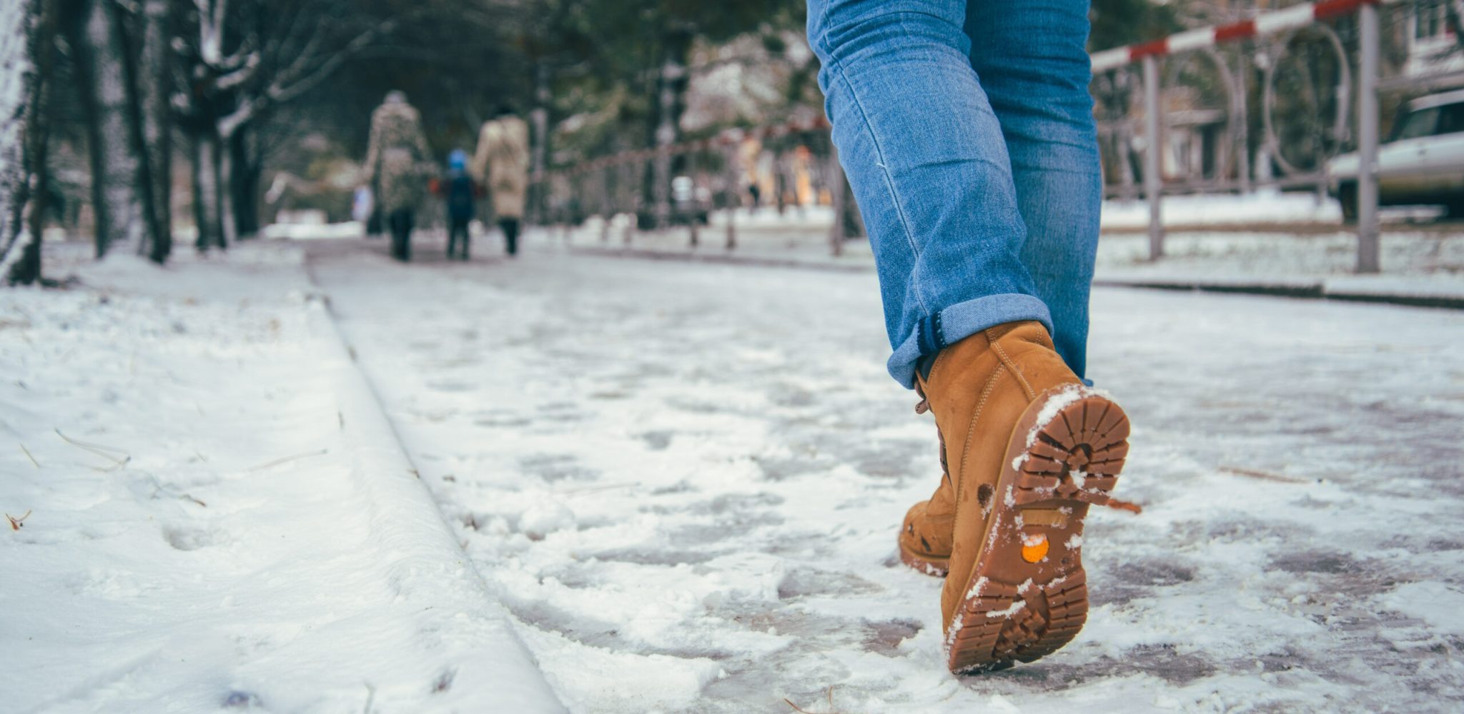 woman walking in winter city road, boots close up